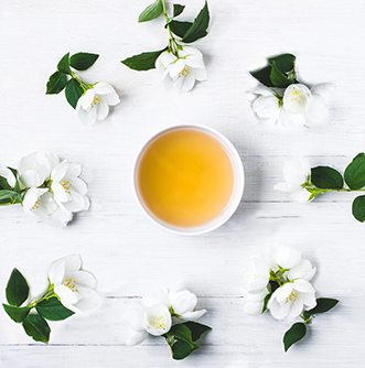 A Tea cup arranged with white Flowers by Anverally